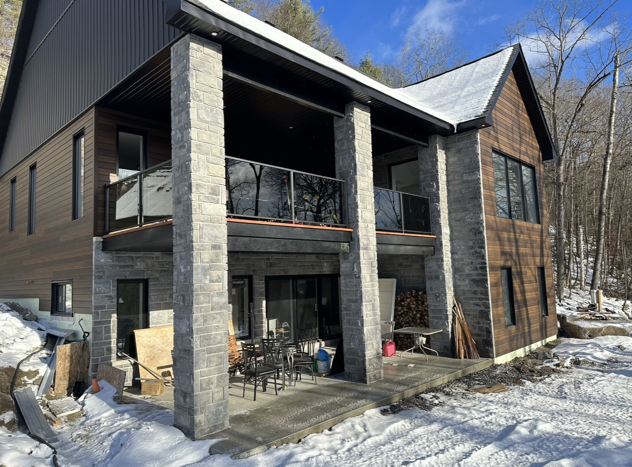 Une grande maison avec un balcon est entourée de neige.