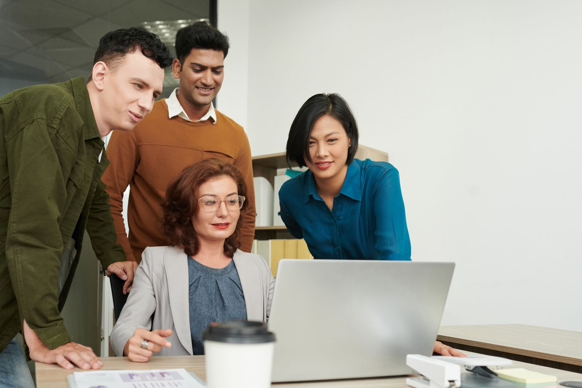 A group of people are looking at a laptop computer.