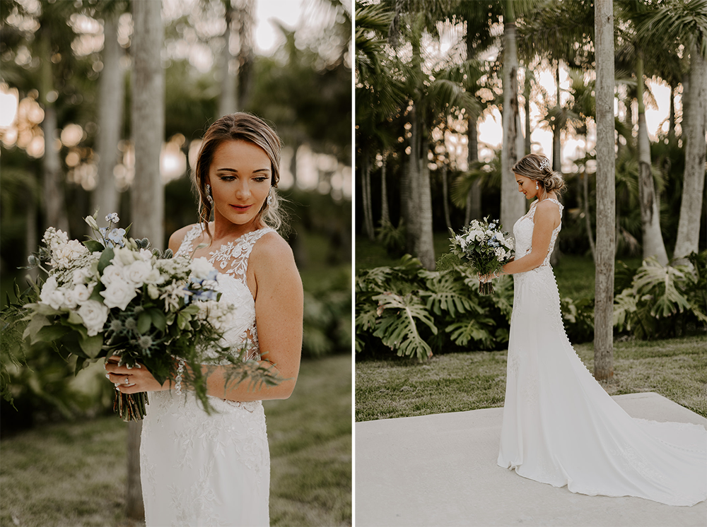 Bride holding bouquet, poses outdoors in a white gown. Lush green trees and foliage in the background.