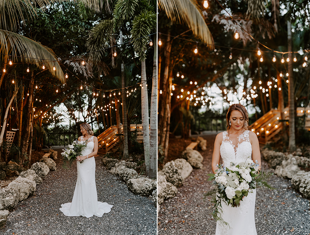 Bride in a white gown holding a bouquet, standing on a path lined with lights and rocks.