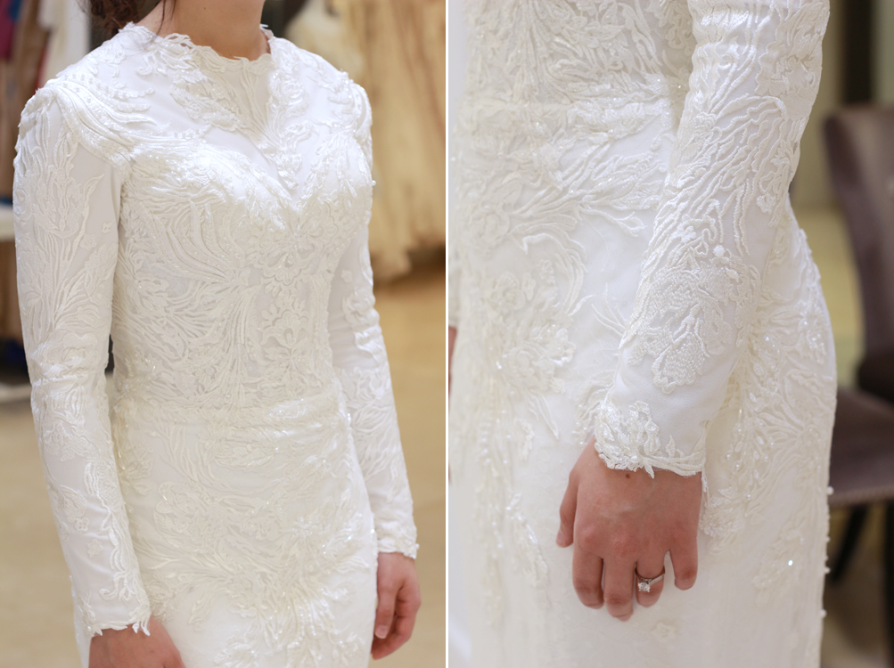 Woman in a white lace long-sleeved wedding dress. Close-up shows detail on sleeves and bodice.
