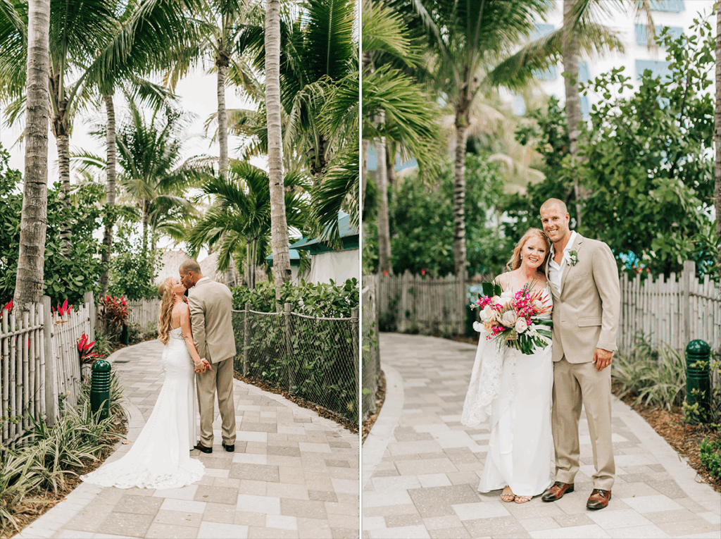 Couple on a brick path, she in a white dress, he in a tan suit, surrounded by palm trees.