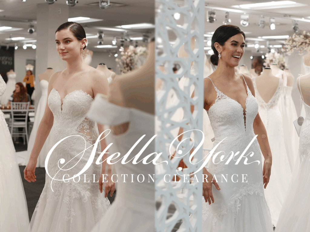 Woman in a white wedding dress smiles, standing near a rack of gowns in a bridal shop. 