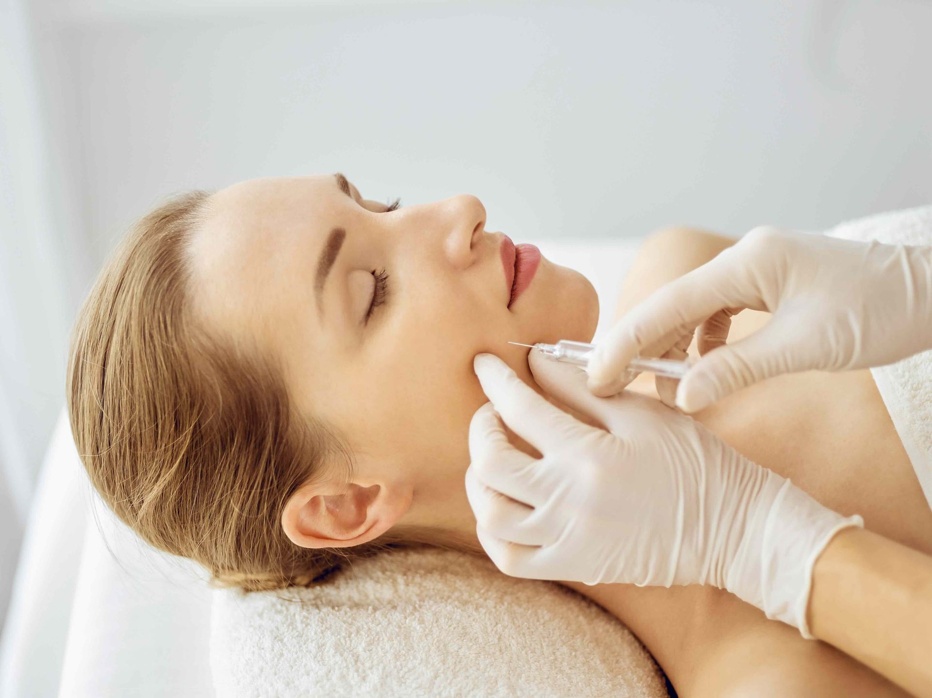 a woman is getting a botox injection in her face