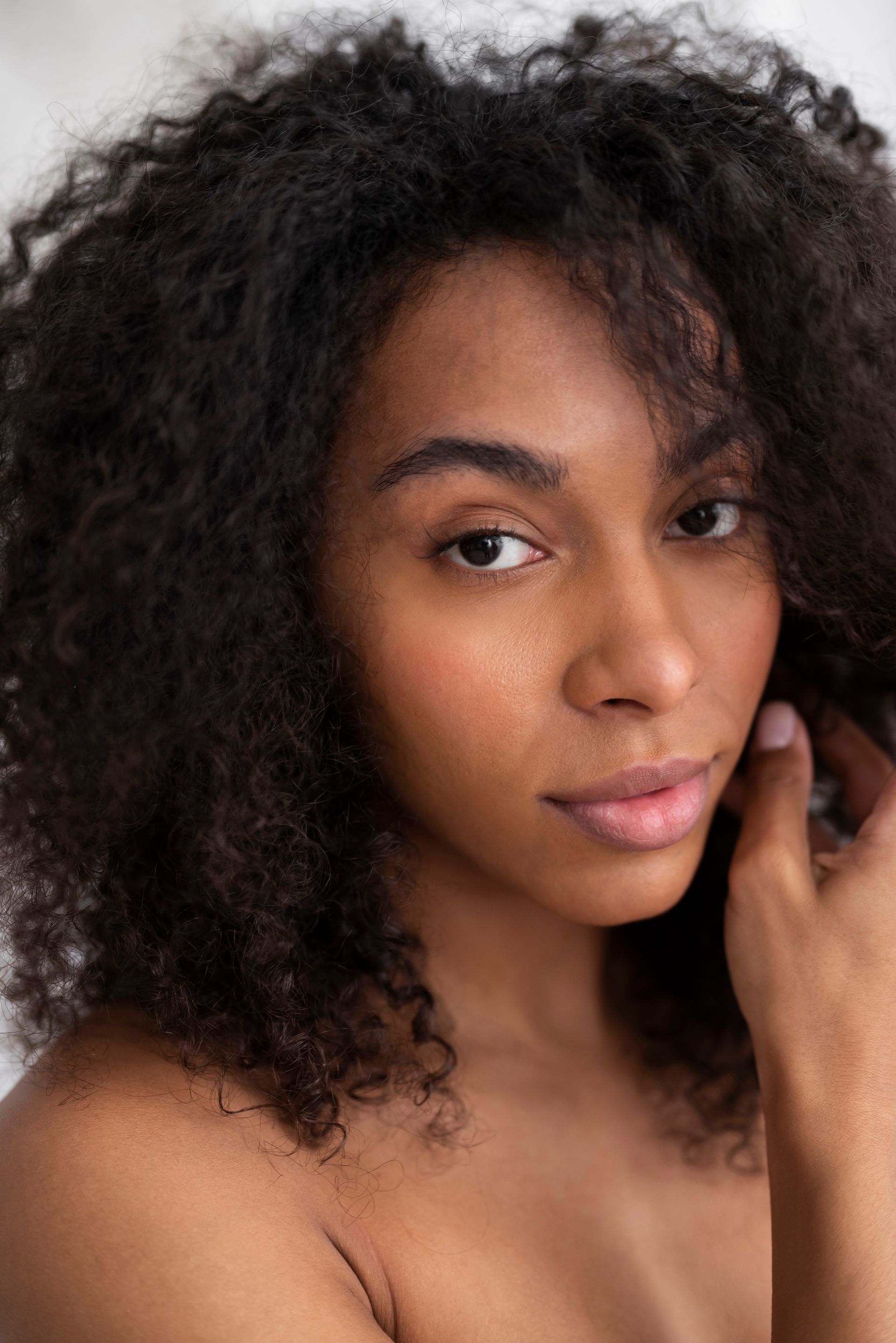 A close up of a woman 's face with curly hair.