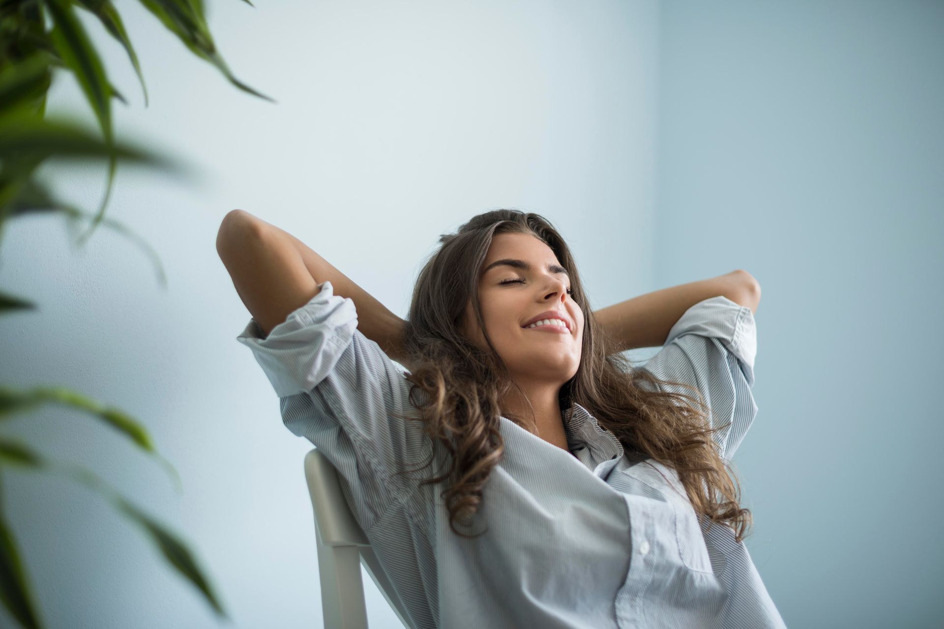 a woman sits in a chair with her eyes closed