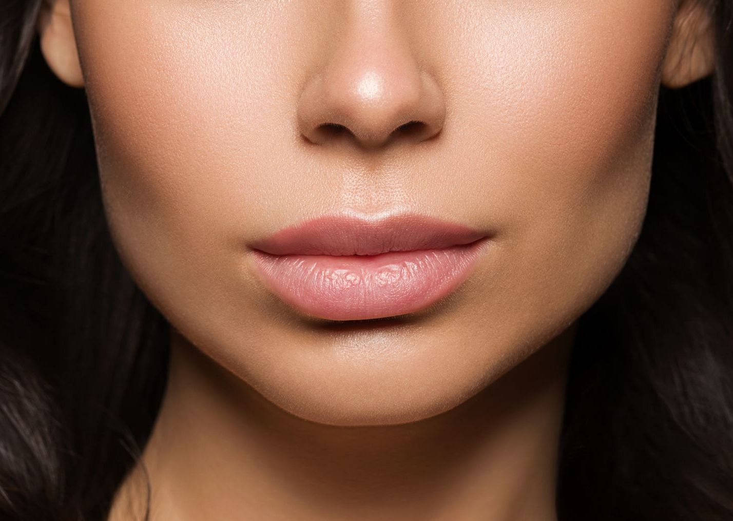 a woman is looking at her face in the mirror