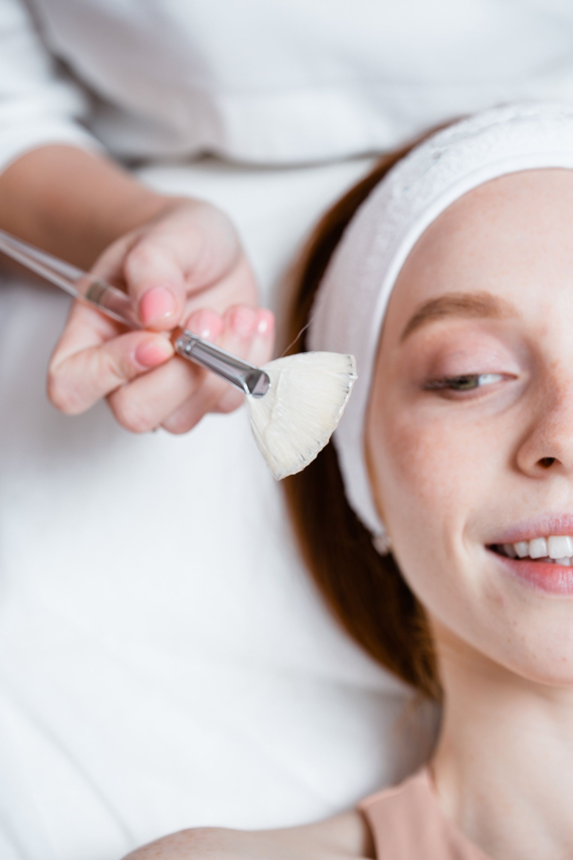 a woman is getting a facial treatment with a brush