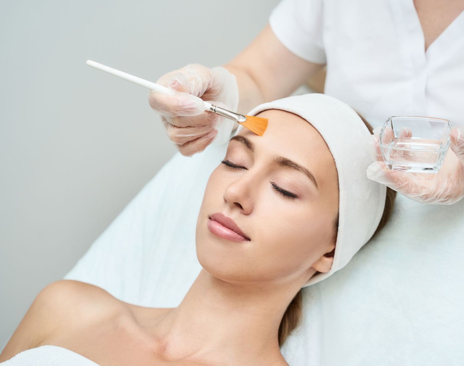 A woman is getting a facial treatment at a beauty salon.