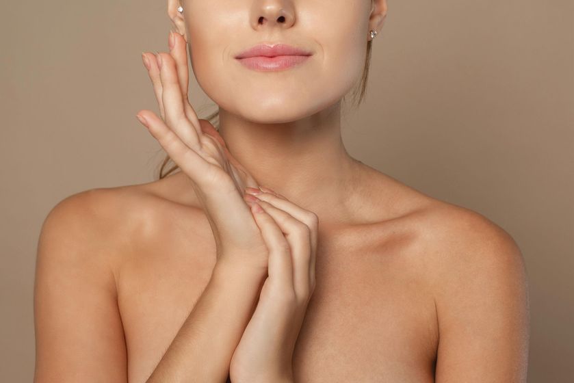 a woman with her hands on her face and neck