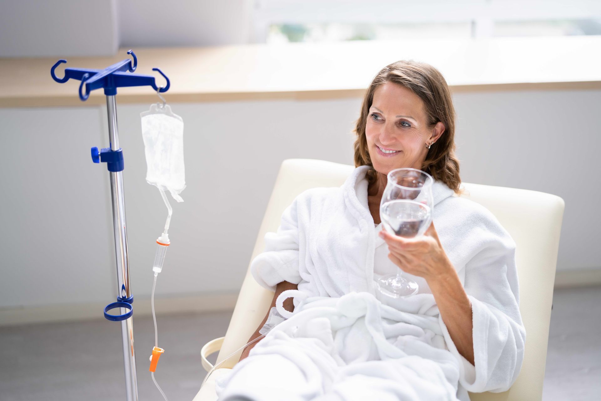 a woman is sitting in a chair holding a glass of water