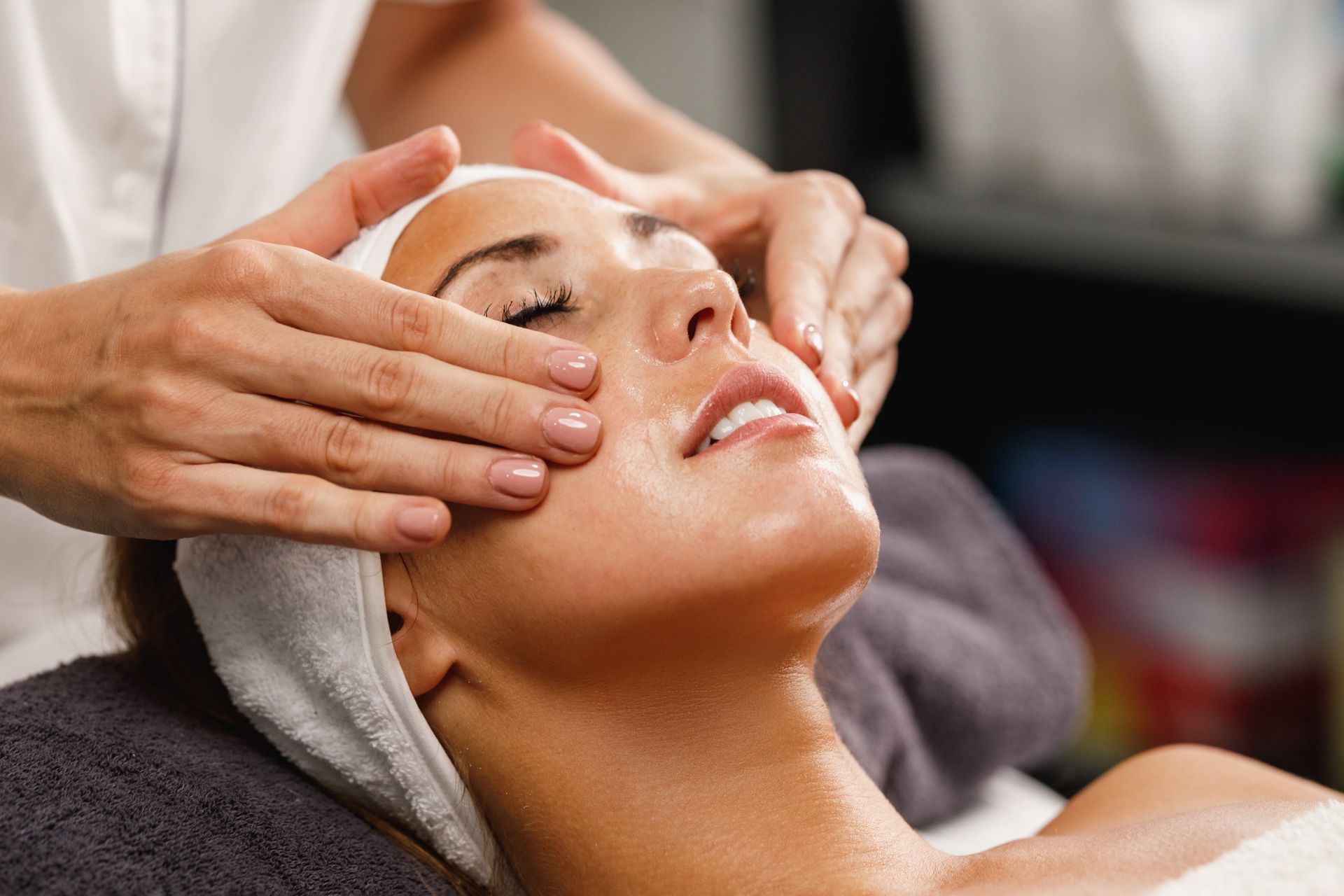 a woman is getting a facial massage with her eyes closed