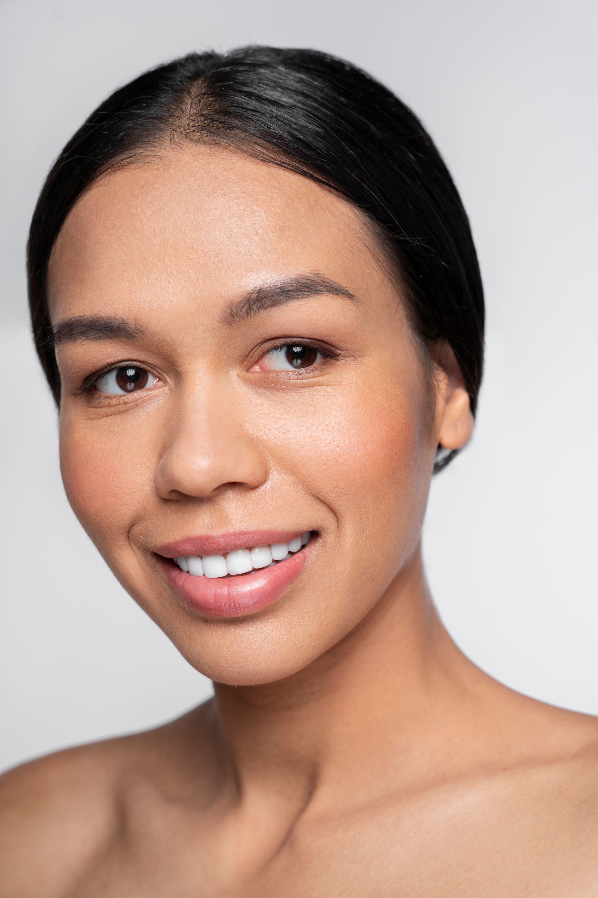 A close up of a woman 's face with a smile on her face.