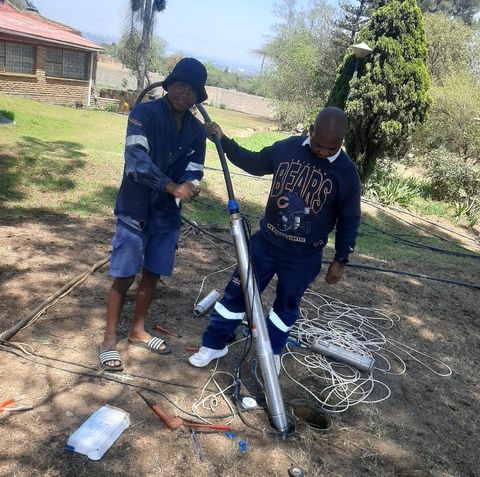 Two men working on a pump