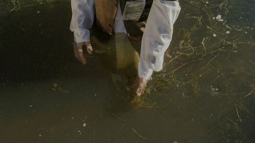 A person is walking barefoot in a puddle of water.