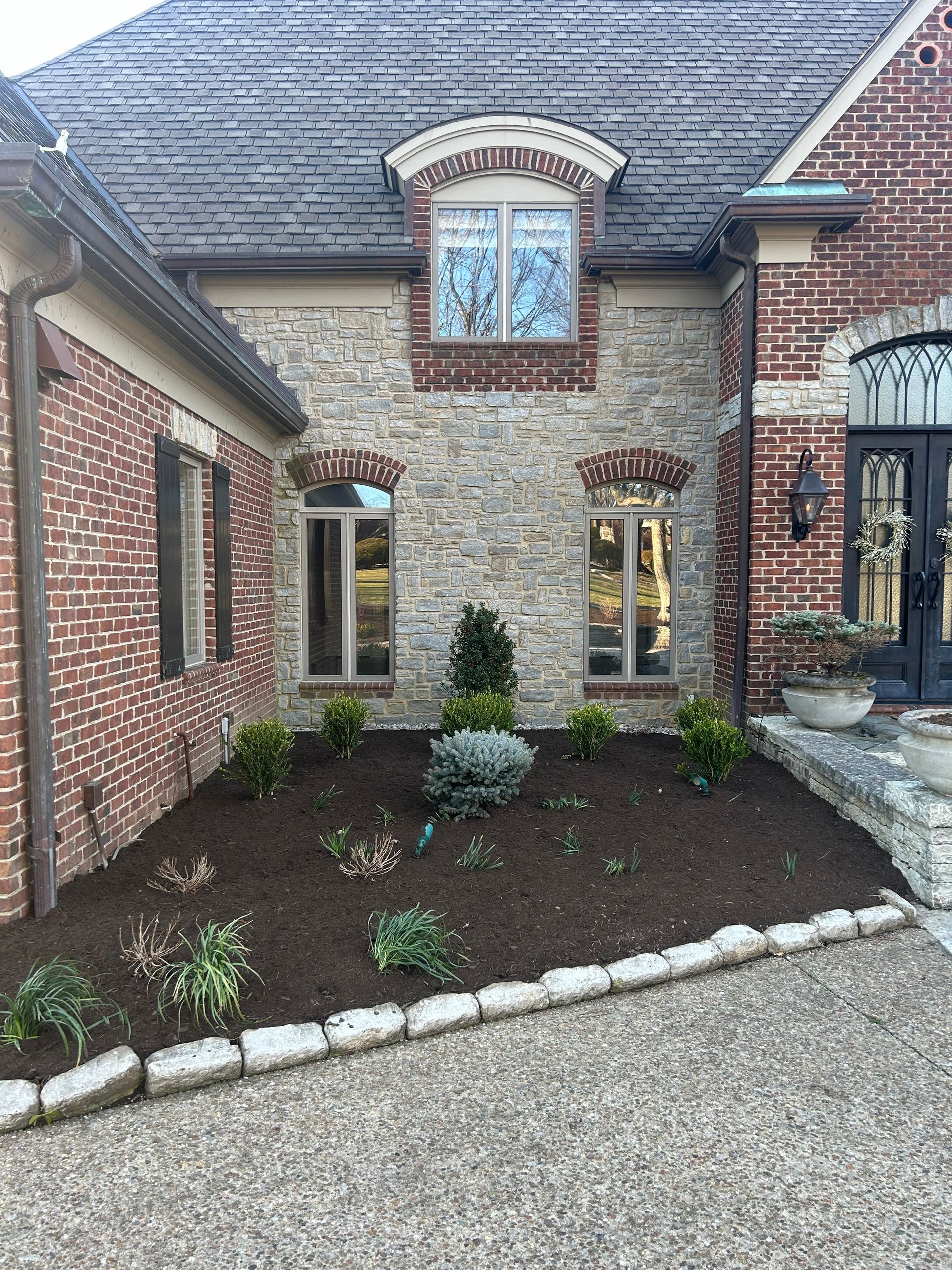 a large brick house with a lush green lawn in front of it . |  Nicholasville, KY | Grassy Lawns
