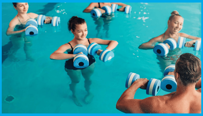Group aqua aerobics class using foam dumbbells in a swimming pool for weight loss and calorie burning