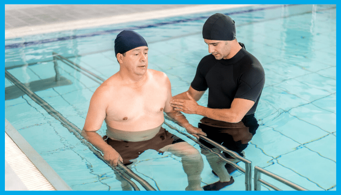 Physiotherapist guiding an older adult through aqua therapy exercises in a pool for safe rehabilitation