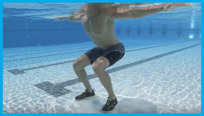 Man doing underwater squat exercise in a pool for aqua therapy