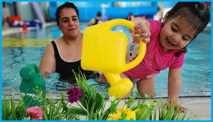Toddler enjoying playful swimming lesson with parent in a baby-friendly swim school facility in Canberra