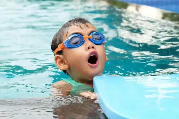 A close-up of a child learning how to swim in a pool