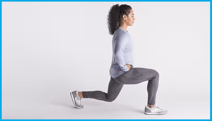 Woman in workout attire performs a lunge, one leg forward, arms at her sides, in a studio setting.