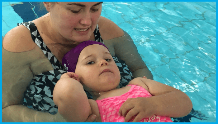 Mother supporting toddler while practicing safe floating technique during swimming lesson in Canberra