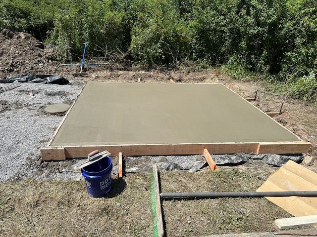 A blue bucket is sitting on top of a concrete slab.