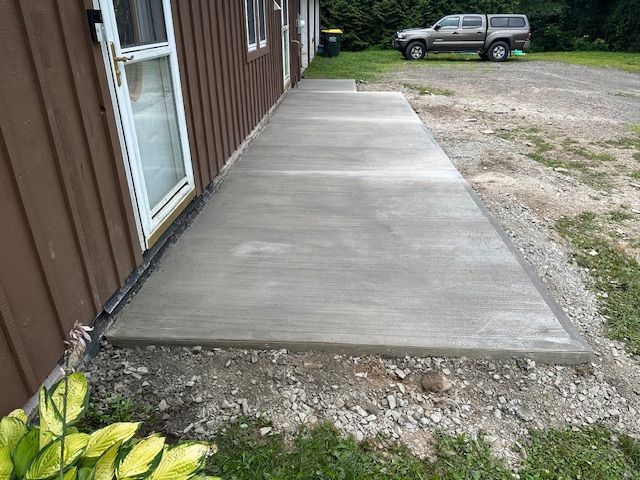 A concrete walkway is being built in front of a house.