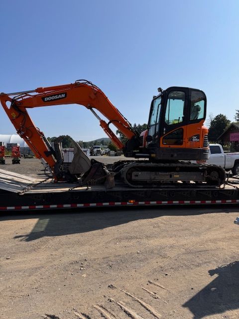 A doosan excavator is sitting on top of a trailer