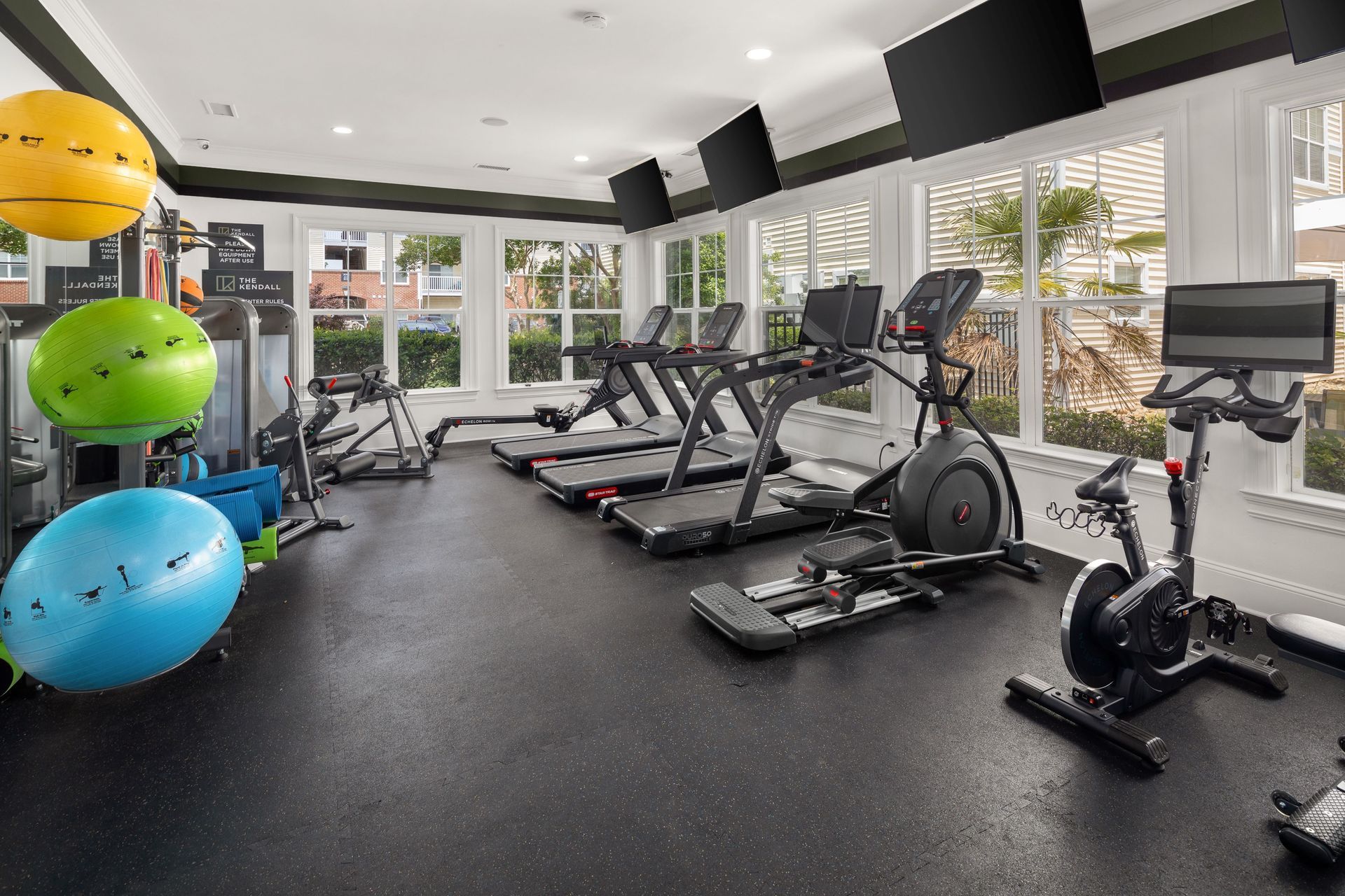 a gym filled with exercise equipment including a peloton bike