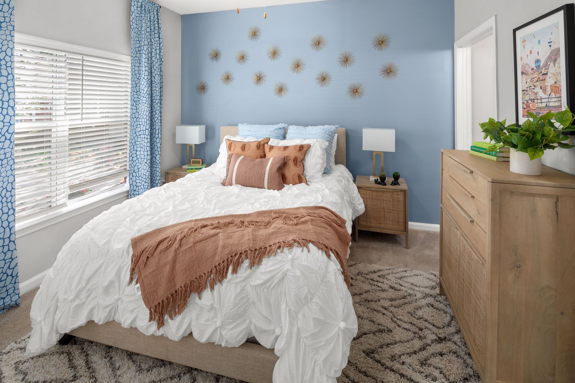 a bedroom with a blue wall and a white bed