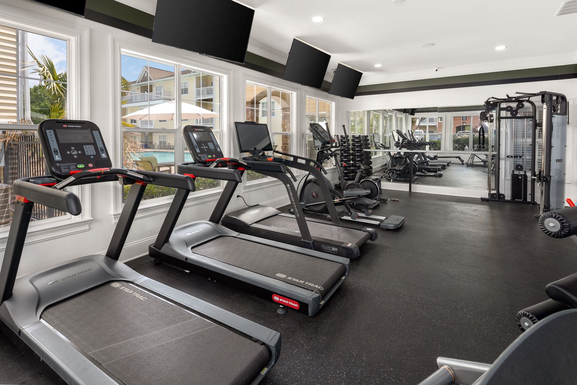 treadmills in a gym with one that has a red stripe on it