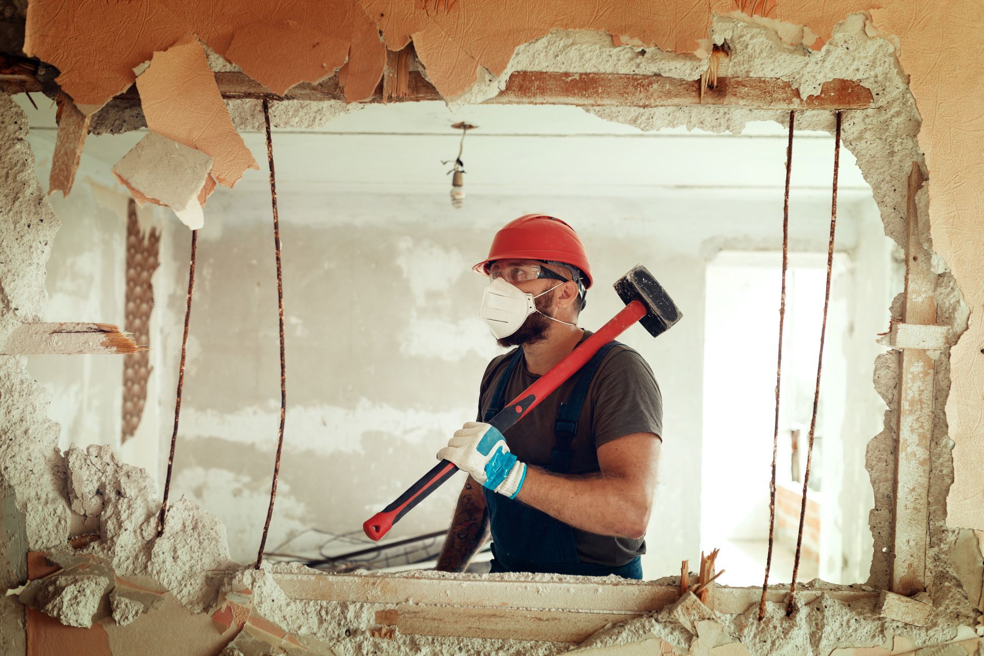 A man is breaking a window with a hammer.