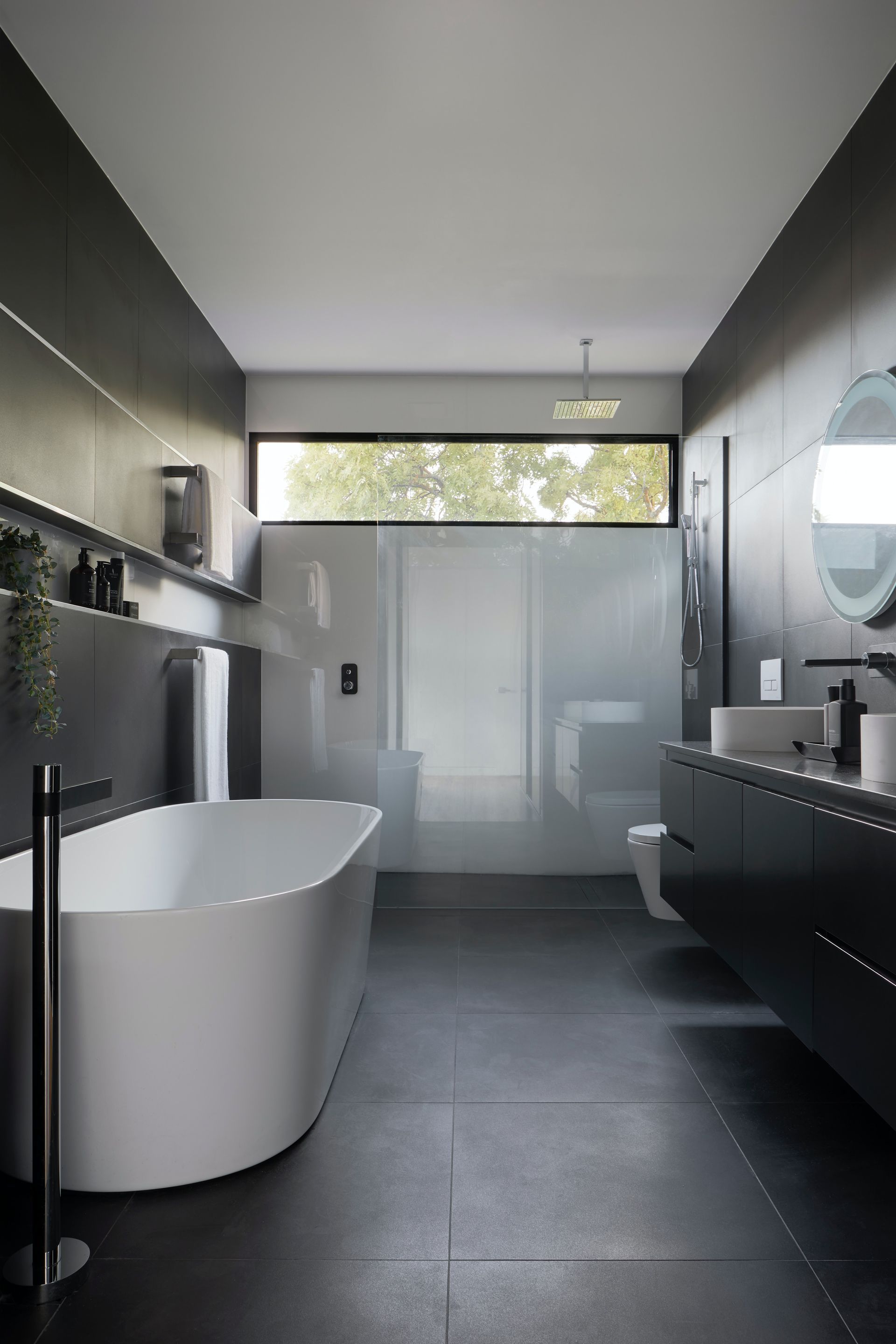 A bathroom with a bathtub , sink , toilet and window.