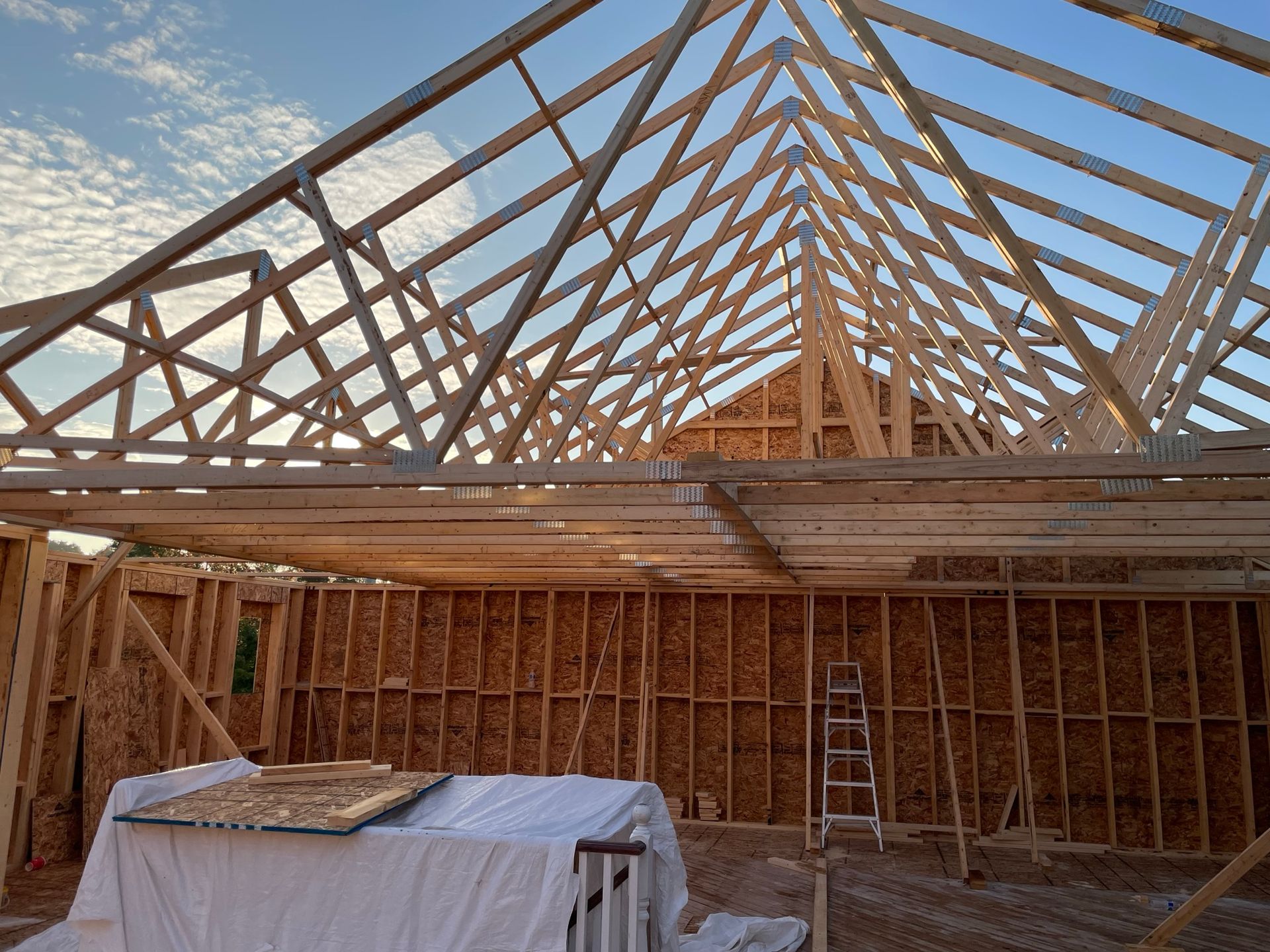 The roof of a house is being built with wooden beams.