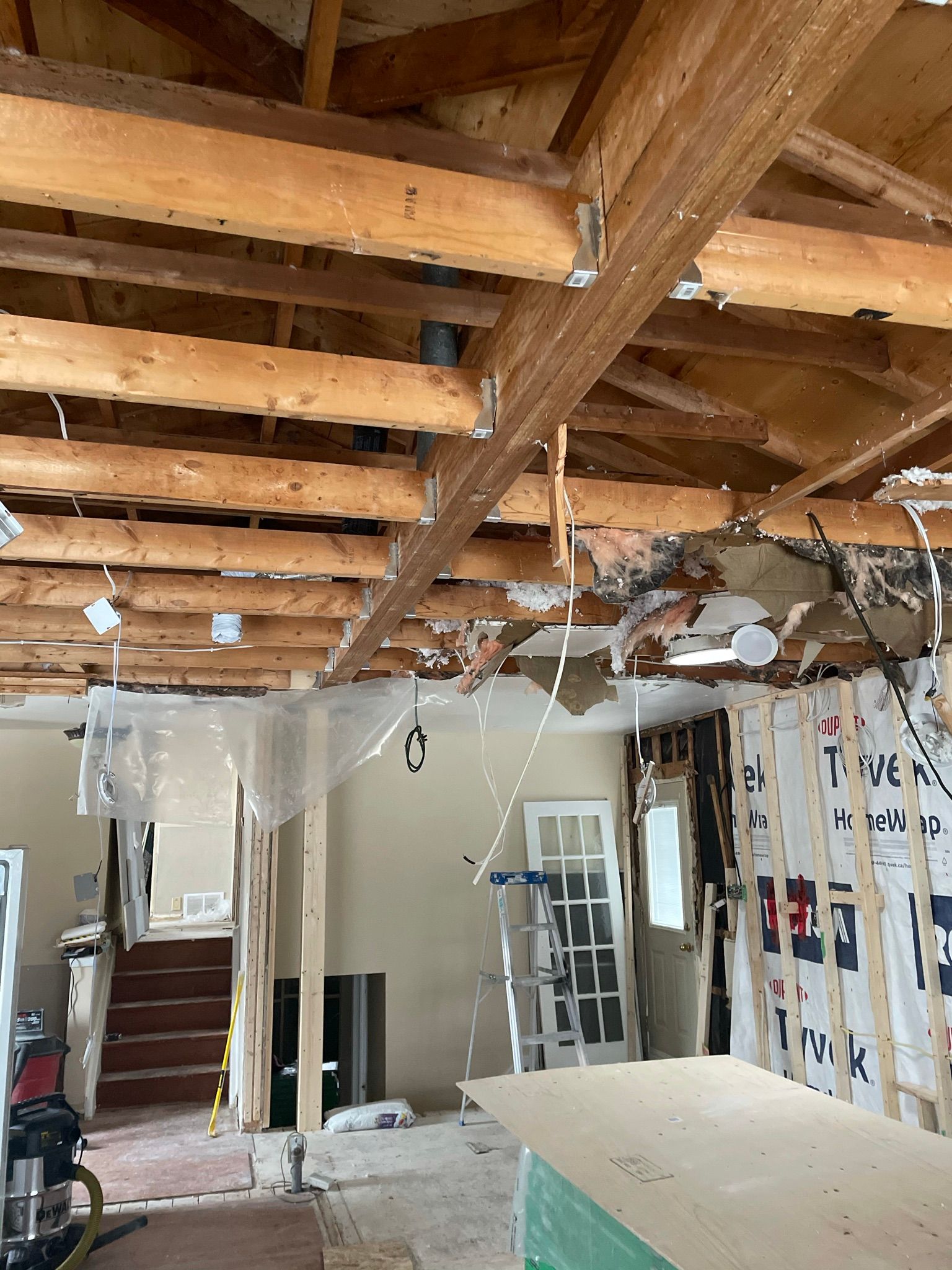 Interior undergoing renovation; exposed beams and drywall removed.