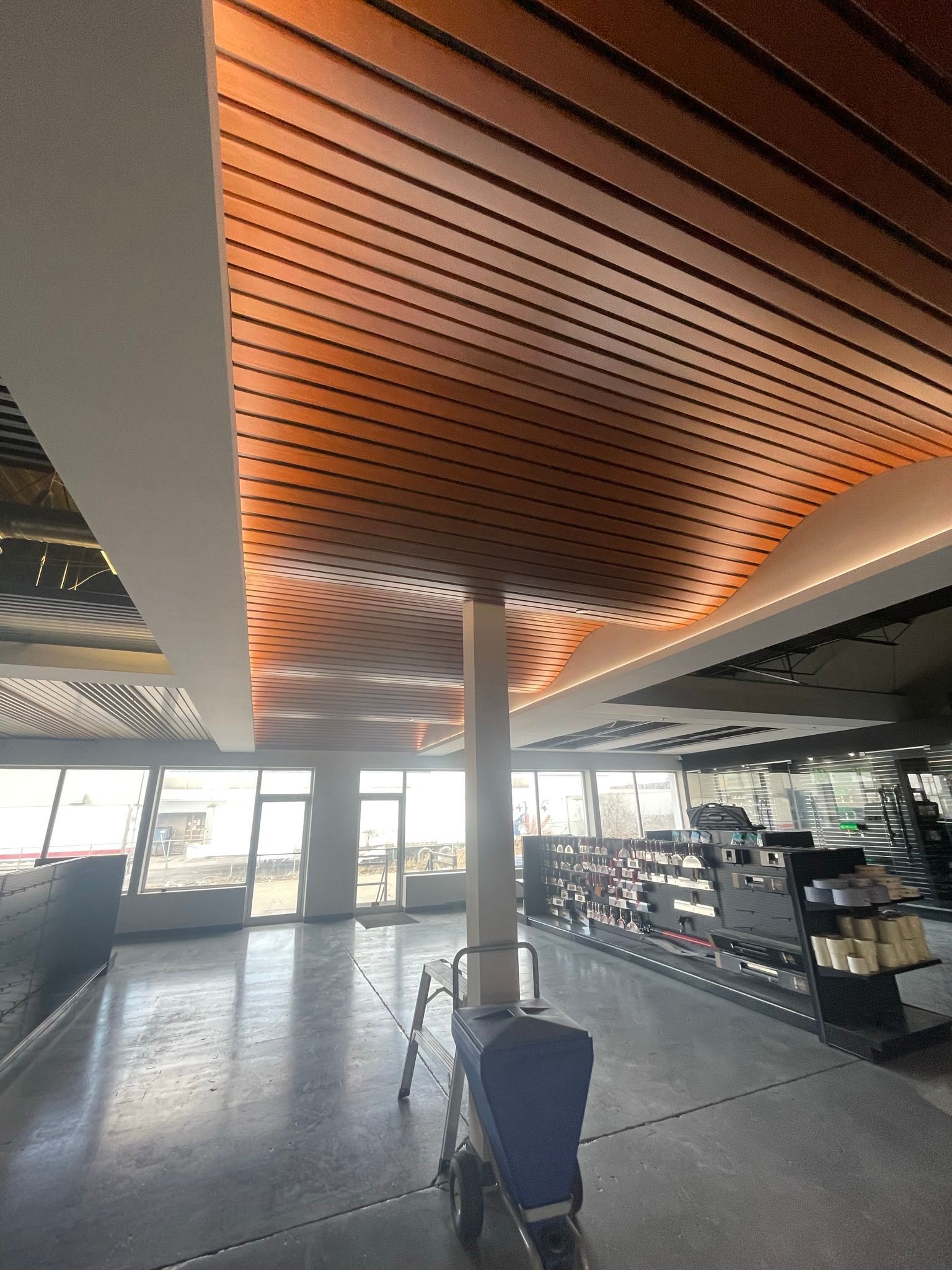 A stroller is sitting in the middle of a large room with a wooden ceiling.