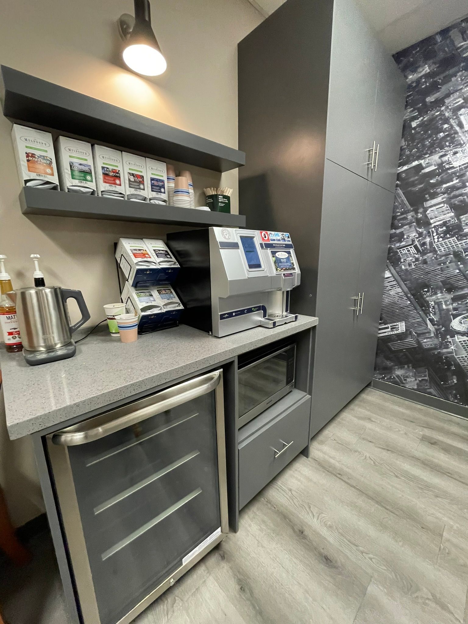 A kitchen with a coffee machine and a refrigerator.