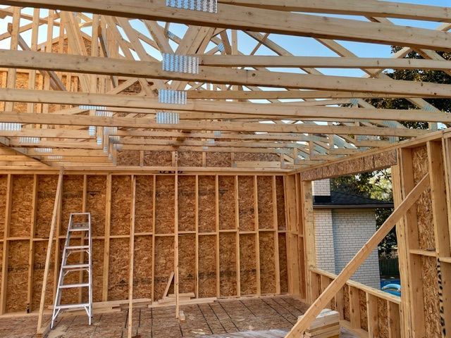 Wooden house frame under construction; interior view.