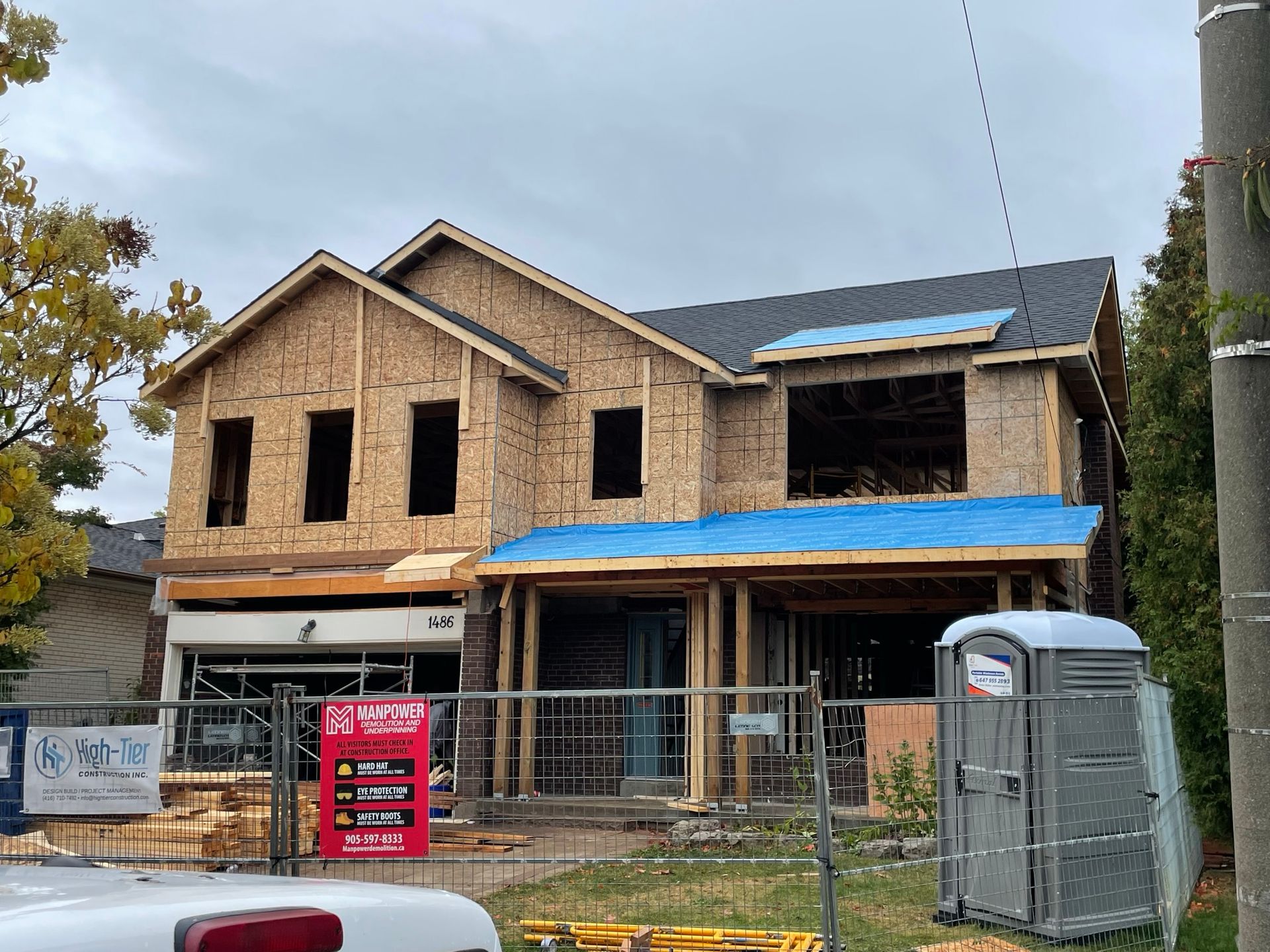 A house is being built with a truck parked in front of it.