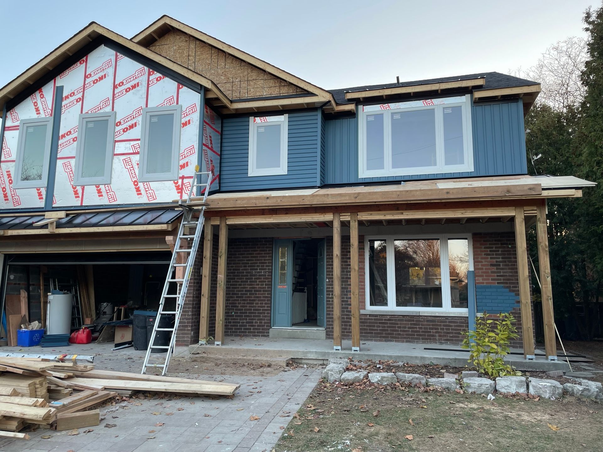 A house is being built with a ladder in front of it.