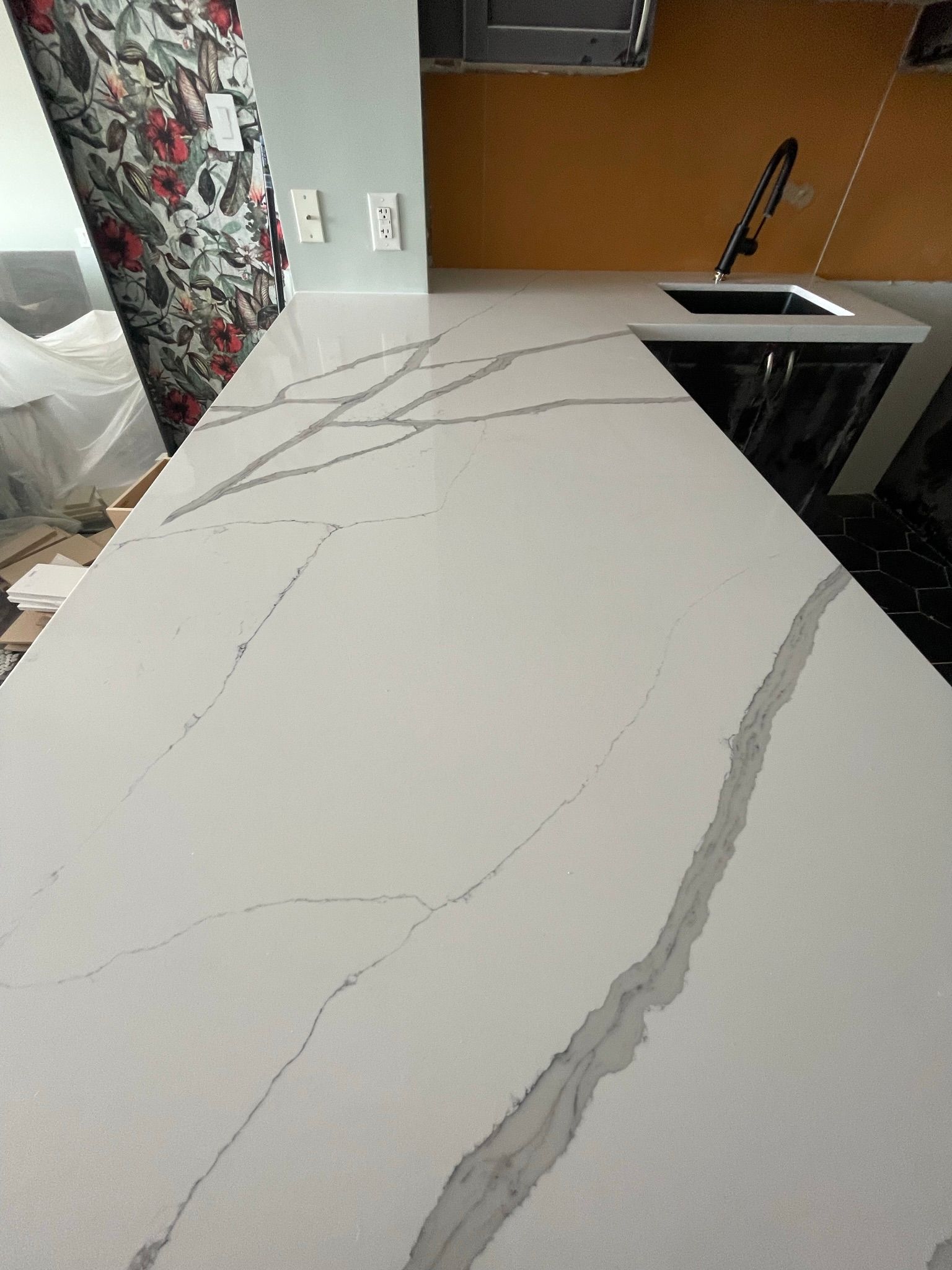 A kitchen with a white counter top and a sink.