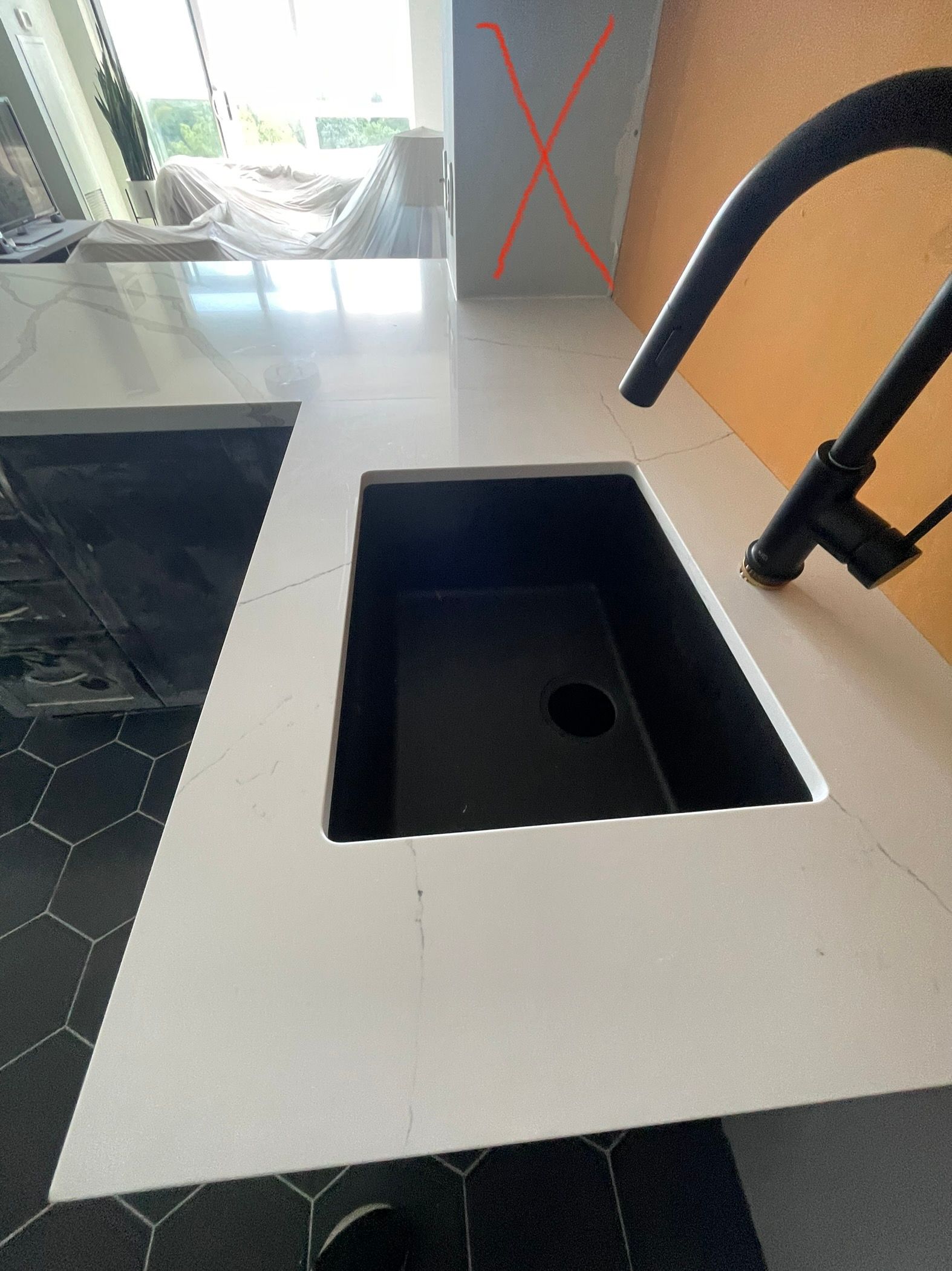 A black sink is sitting on top of a white counter.