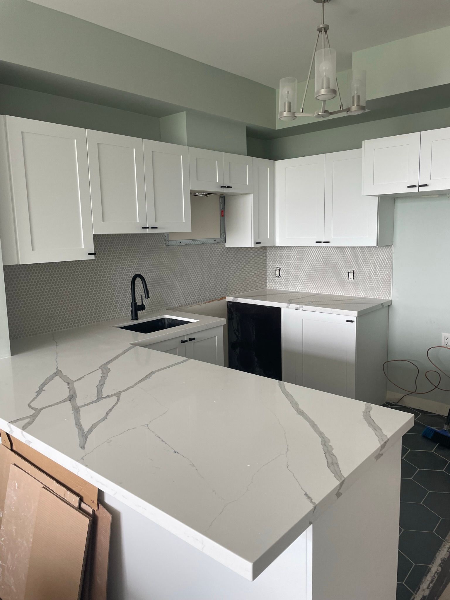 A kitchen with white cabinets and a white counter top.