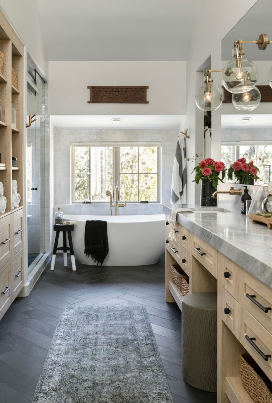 A bathroom with a tub , sink , and mirror.