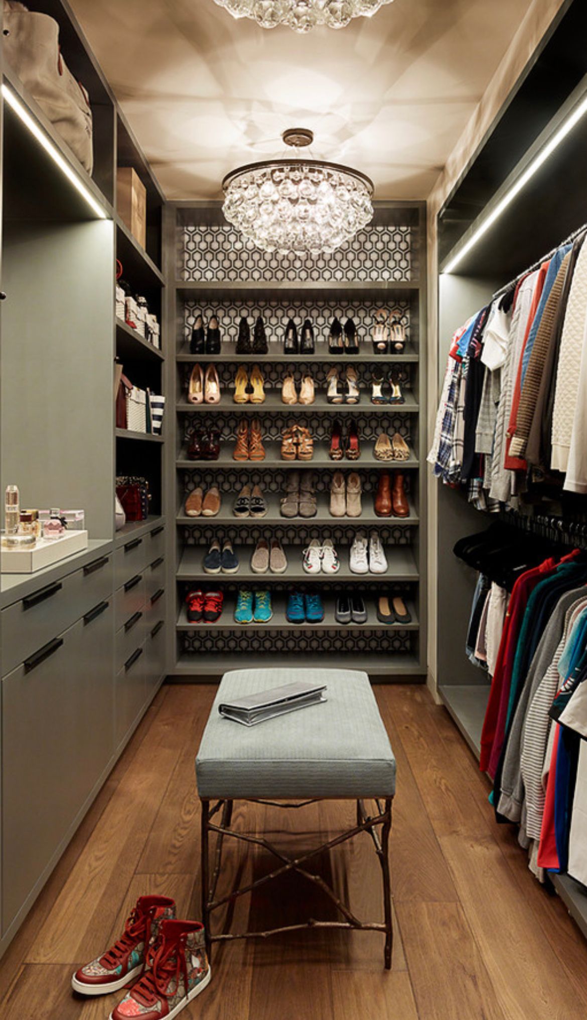 A walk in closet filled with lots of clothes and shoes.