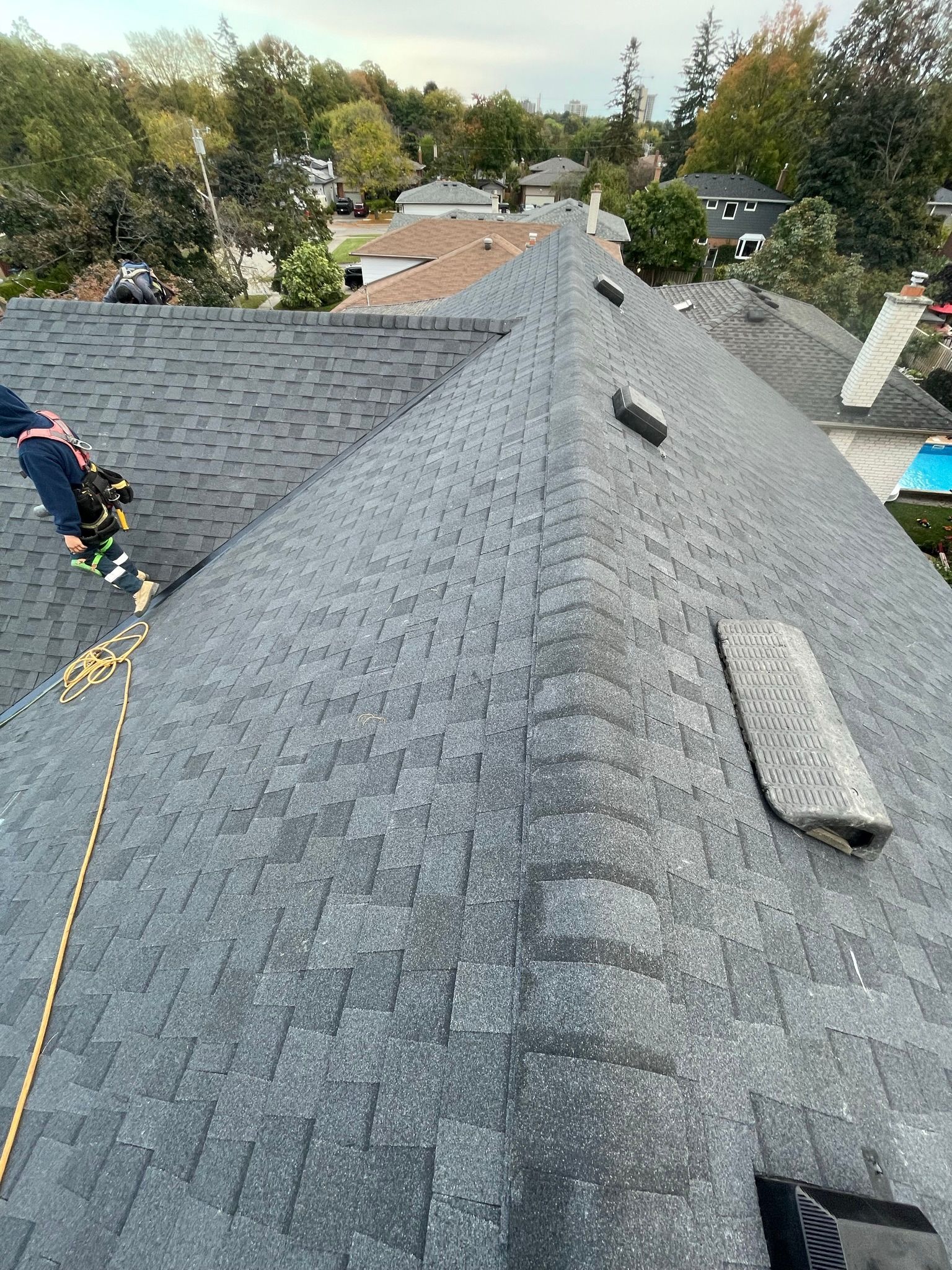 A man is climbing up the roof of a house.
