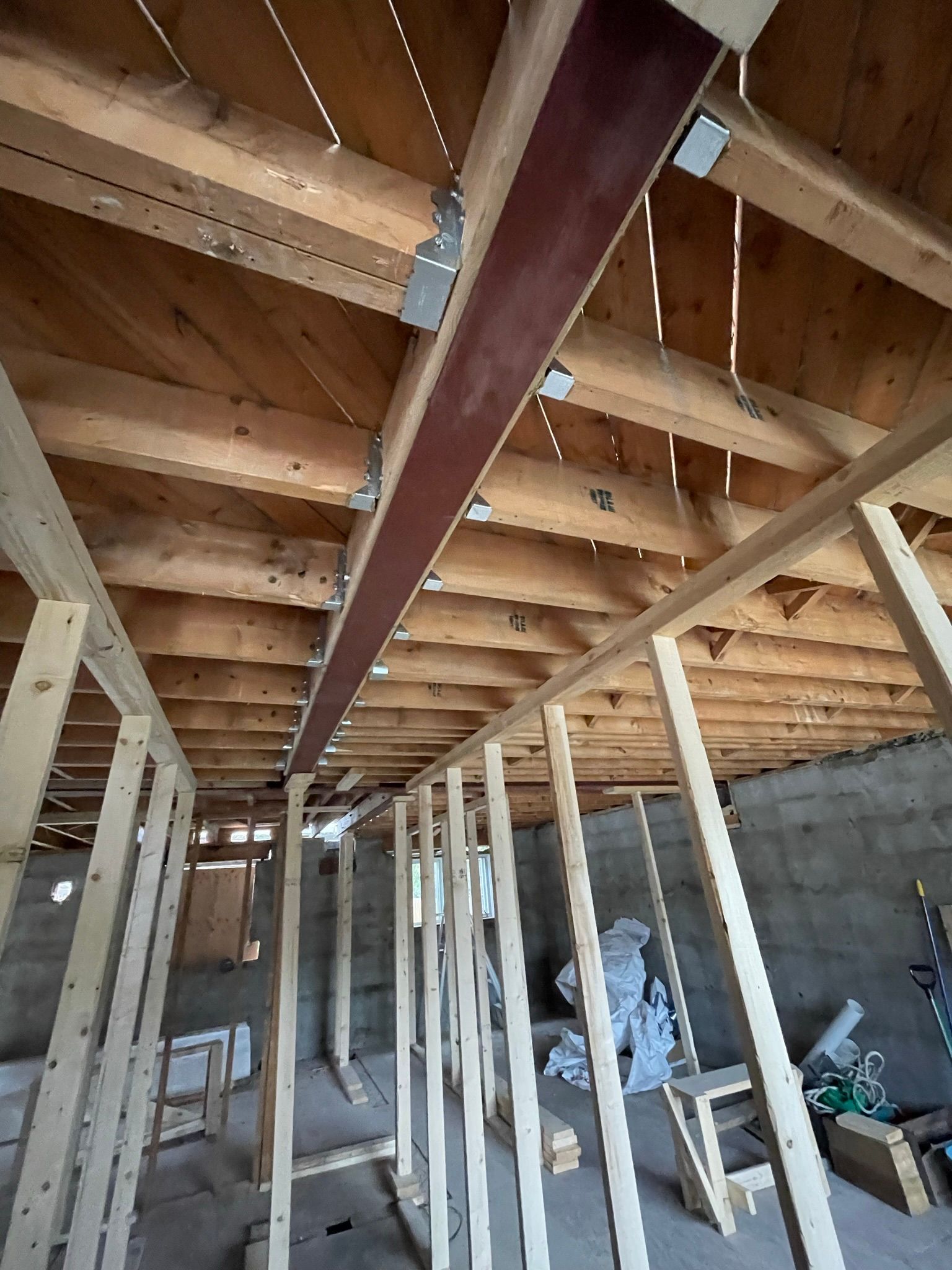 A room under construction with wooden beams and a ceiling.