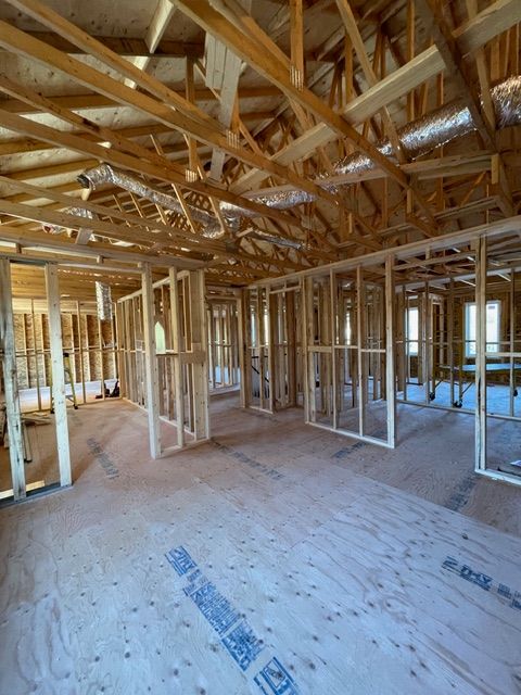 Interior of a house under construction. Wooden framing for walls, ceiling, and floor are visible.